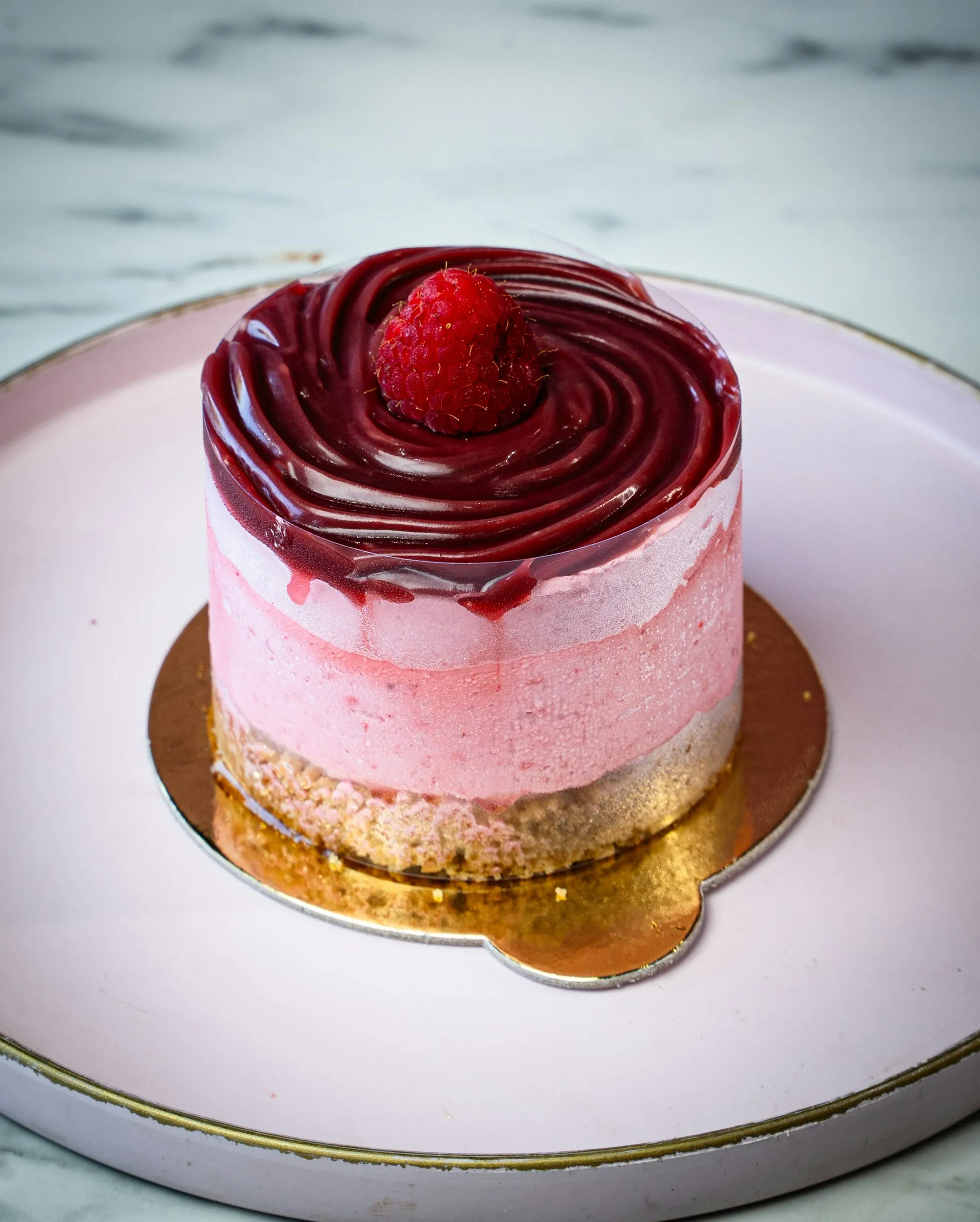 A pink mousse cake glazed in deep raspberry, from our Maison Cerise concept